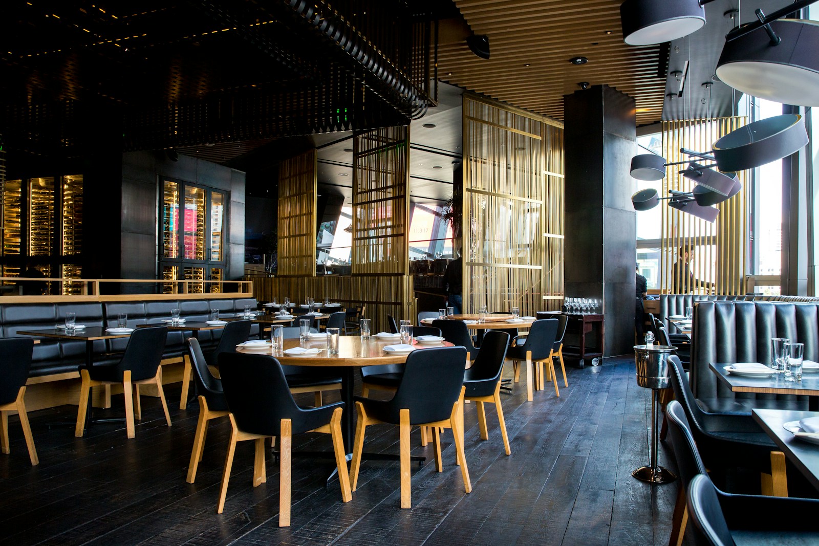 Warm contemporary restaurant interior with tables and pendant lights